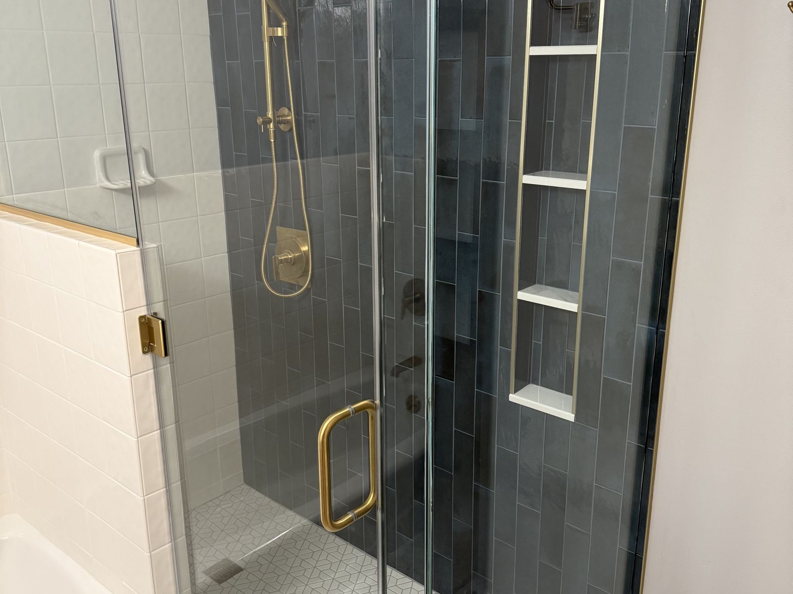 Blue tile shower with brass fixtures