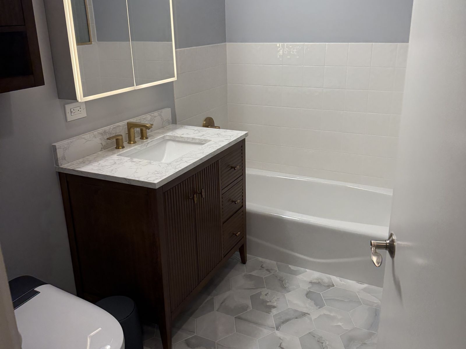 Wood vanity and lit medicine cabinet